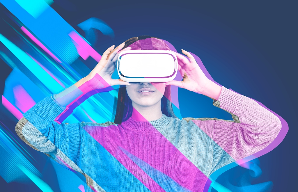 Attractive young woman wearing a sweater and vr glasses standing over a blue background