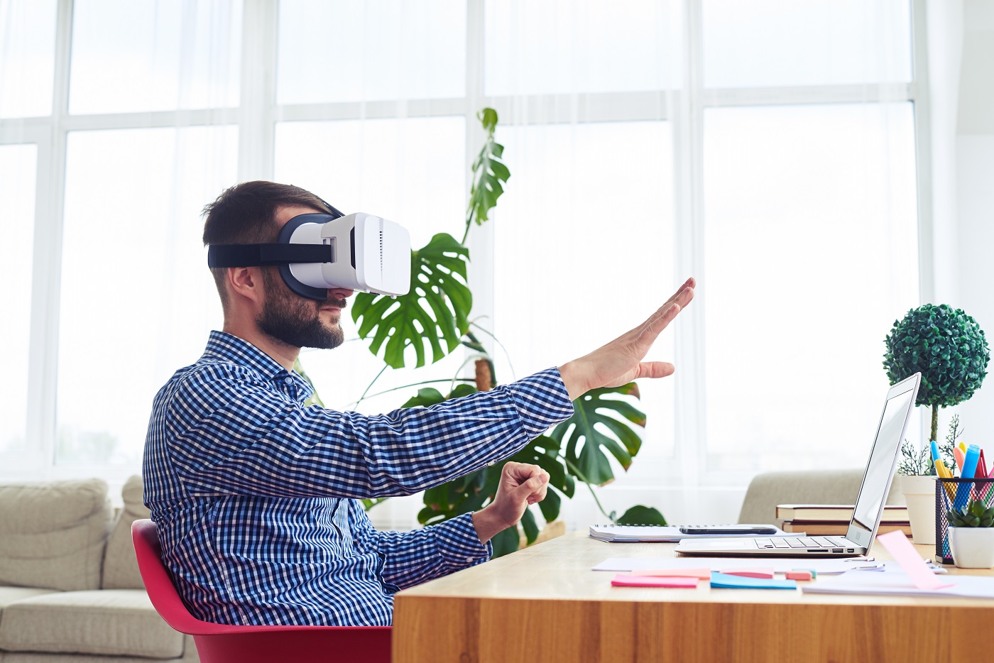 Man with VR headset sitting at a desk