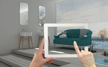 Augmented reality concept. Hand holding tablet with AR application used to simulate furniture and interior design products in real home