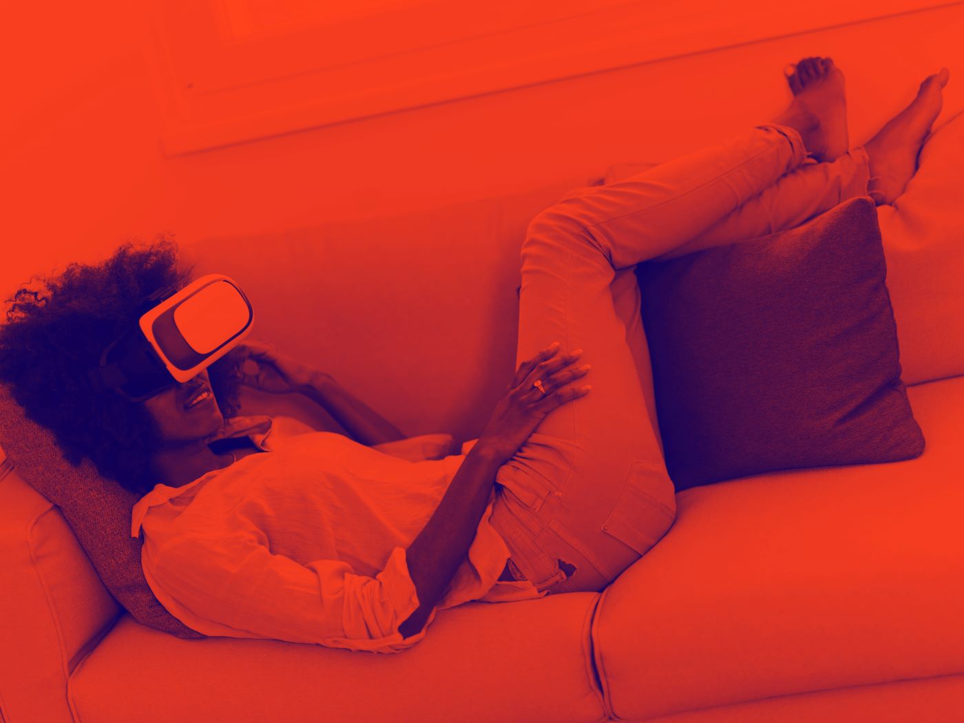 woman lying on the couch with virtual reality glasses