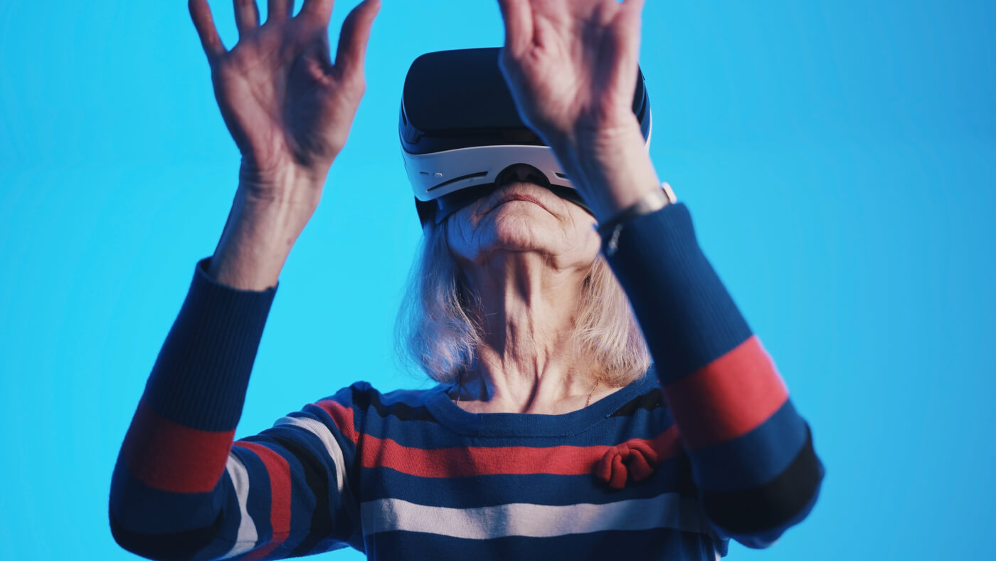 Old woman pensioner experiencing Virtual Reality