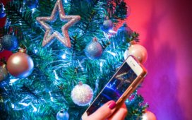 Christmas tree, hand holding a smart phone - symbolizing holiday mobile AR experiences