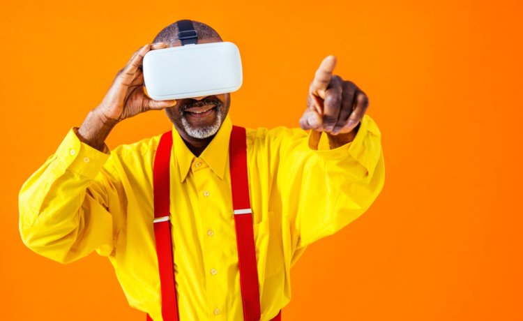 Cool senior man with fashionable clothing using a VR headset
